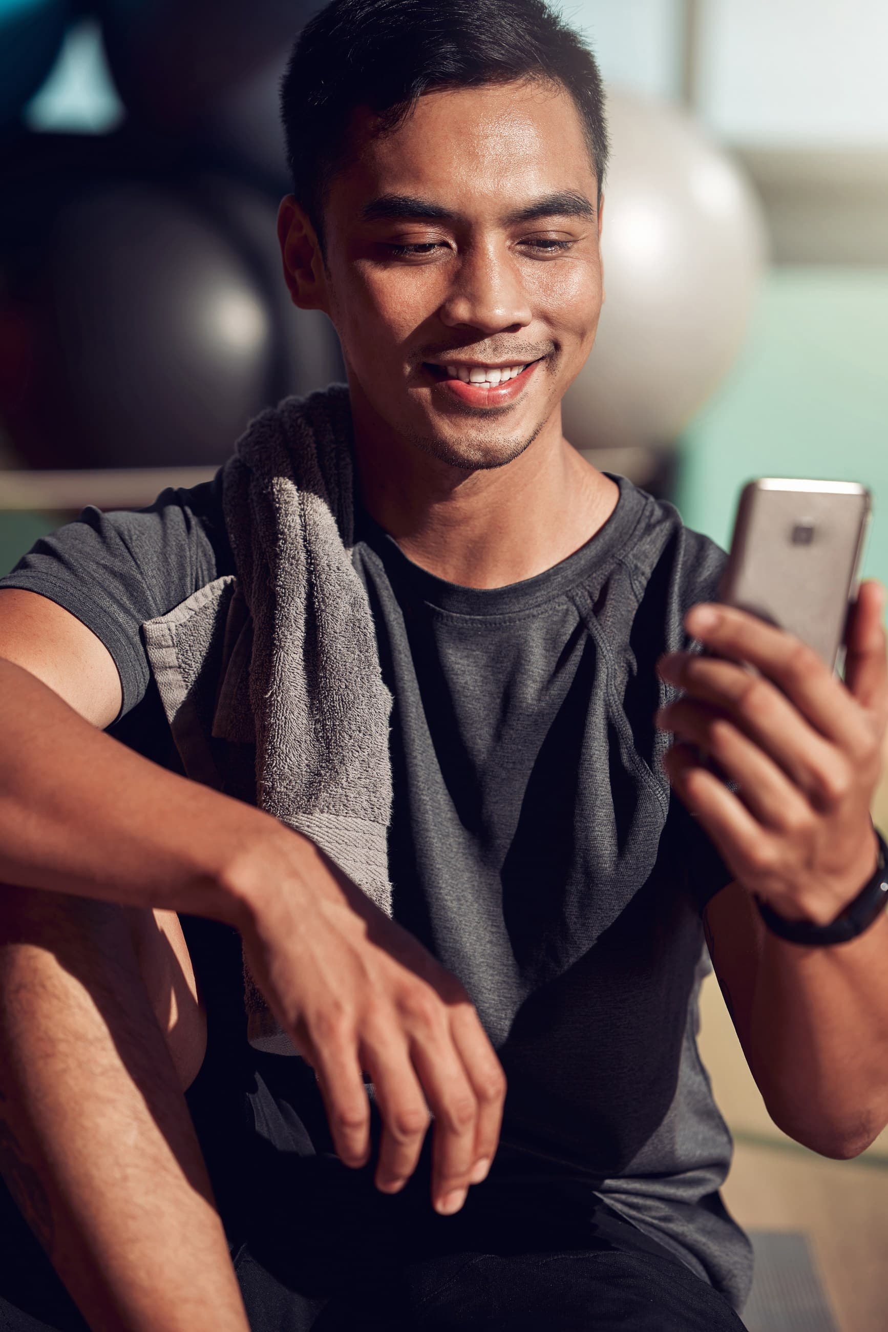 Gym member smiling while checking his phone